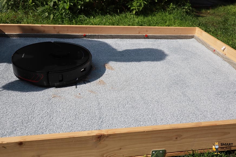 The Roborock S7 MaxV vacuums sand on a carpet.